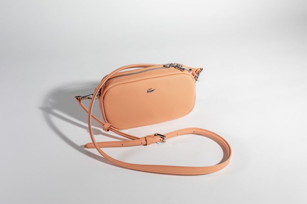Photo d'un sac pochette Lacoste de couleur pêche, une idée cadeau fête des mères mode outlet
