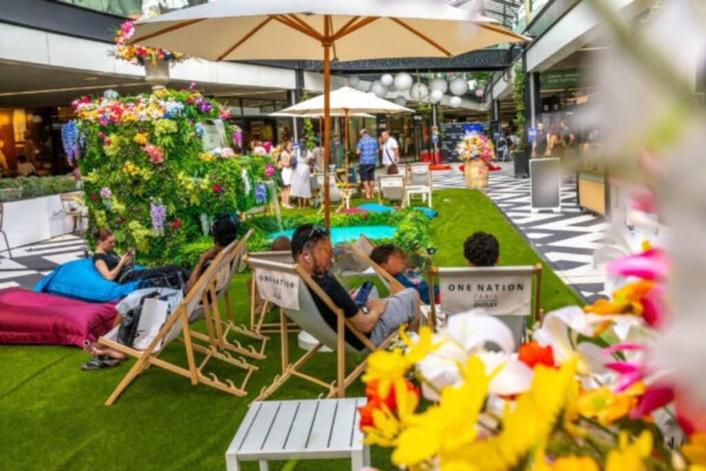 Photo d'une terrasse aménagée au coeur du centre commercial One Nation, outlet Versailles, pendant les soldes d'été 2026